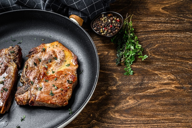 Roasted pork steaks in frying pan from neck meat