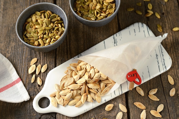 Roasted pumpkin seeds on a wooden background