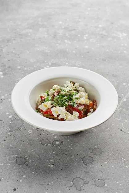 Roasted red sweet peppers and Basil with feta cheese, on a light stone surface