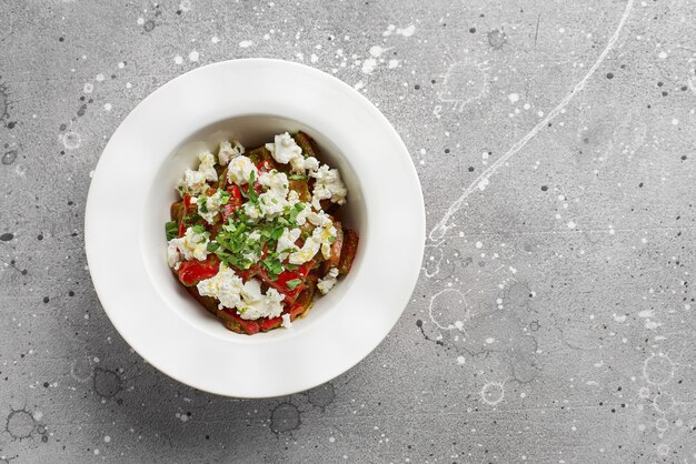 Roasted red sweet peppers and Basil with feta cheese, on a light stone surface