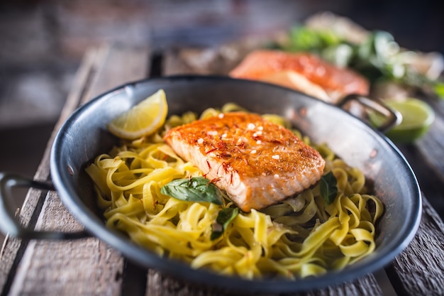 Roasted salmon fillet with pasta tagliatelle lemon and basil.