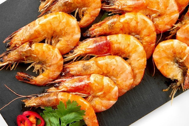 Roasted shrimp in spices on a black slate White background selective focus