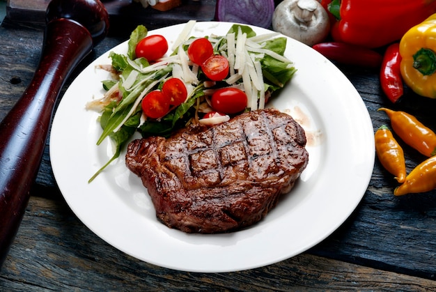 Roasted steak with cherry tomato and lettuce salad and grated parmesan