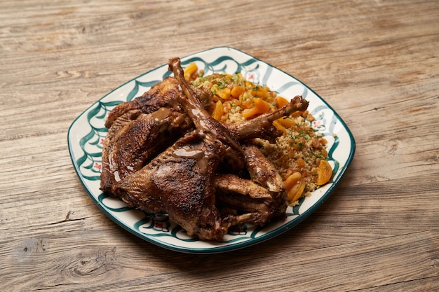 Roasted turkey and couscous on wooden table background with copy space.