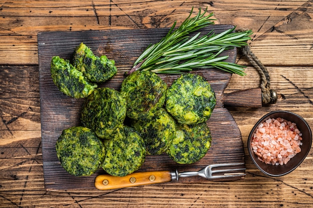 Roasted vegetarian broccoli and pea vegetable patty or cutlet, falafel. wooden background. Top view.