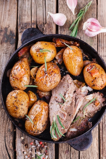 Roasted young potatoes in the pan. With meat, garlic , bacon 