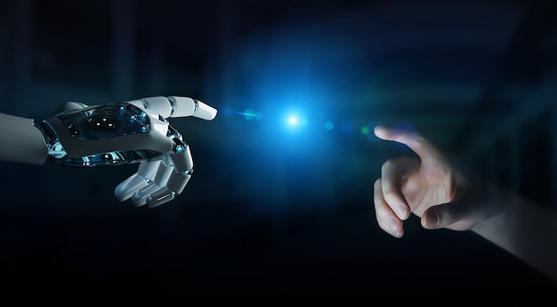 Robot hand making contact with human hand on dark background