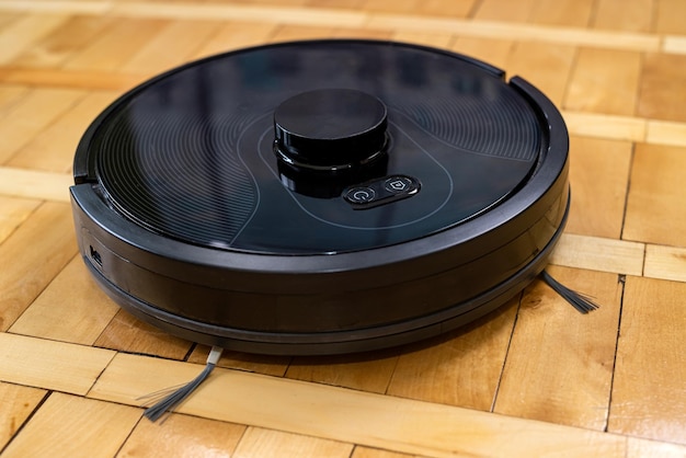 Robot vacuum cleaner on a laminated wooden floor with a remote control