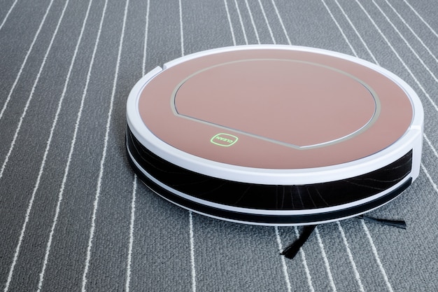 Robotic vacuum cleaner on grey carpet