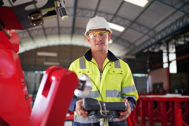 Robotics engineer working on maintenance of modern robotic arm in factory warehouse Business technoloy