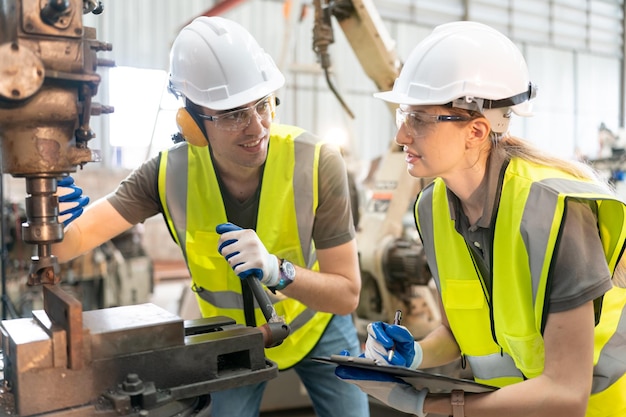 Robotics engineer working on maintenance of modern robotic arm in factory warehouse