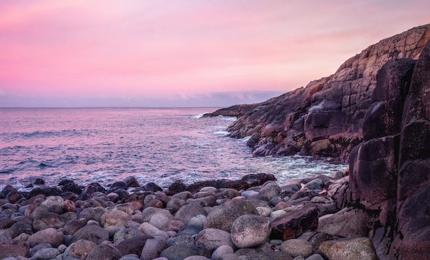 A rock cliff above the water with a tidal shoreline. Wonderful panoramic mountain landscape on the Barents sea. Teriberka. Russia.