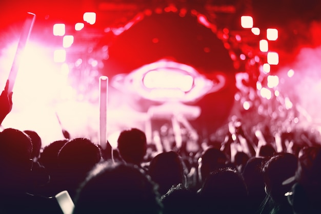 Rock concert with silhouettes people in happy gesture and raising up hands for cheer up singer