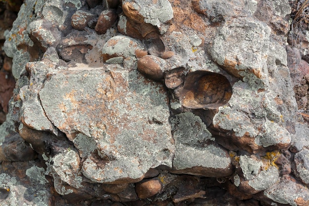 Rock consisting of stones covered with green moss and lichen. Horizontal image.