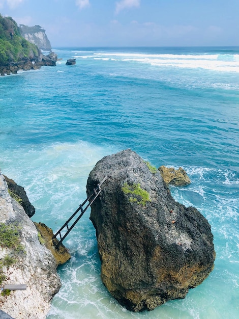 Rock formation in sea against sky