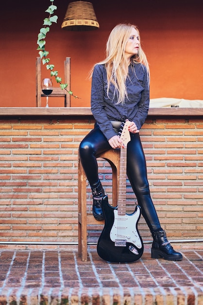 Rocker woman posing with a guitar.