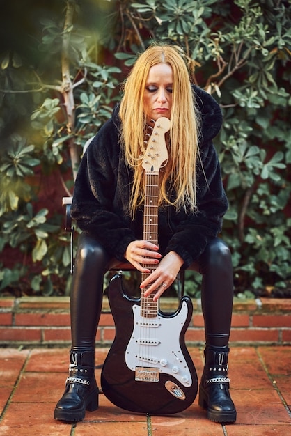 Rocker woman posing with a guitar.