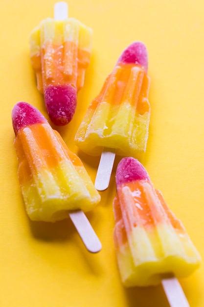 Rocket shaped summer ice lolly on a bright yellow background