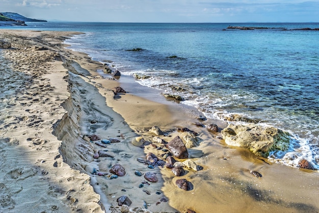 Rocks and sand by the shore in Castelsardo Italy