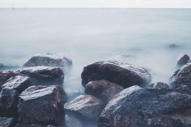 Photo rocks in sea against sky