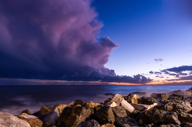 Rocky beach at sunset with storm clouds