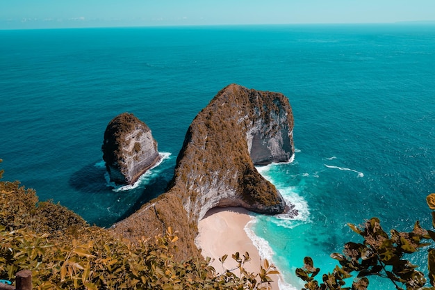 A rocky beach with a pink sand beach in the background