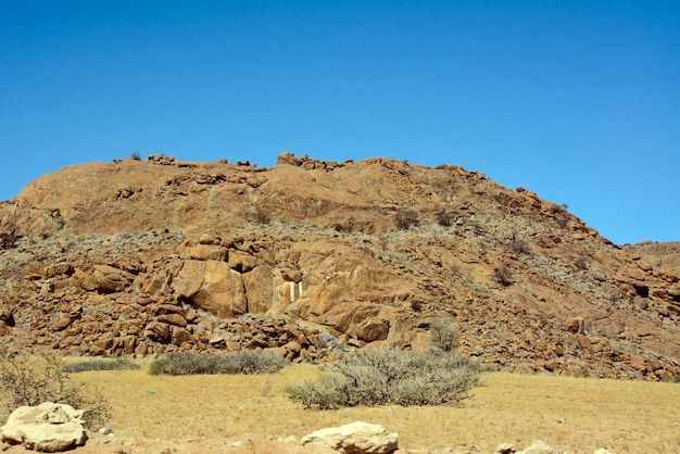 A rocky hill in the desert against a clear blue sky World climate change and global warming