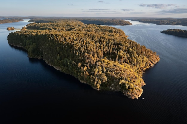 Rocky island overgrown with trees in archipelago of small islands on Ladoga Lake Karelia Russia