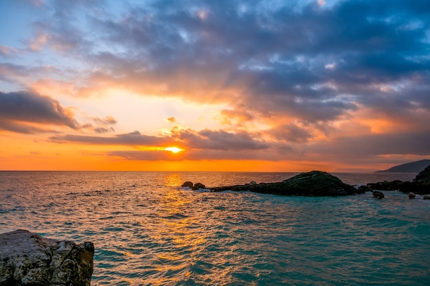 Rocky seashore. A lot of clouds in the sky and sun rays