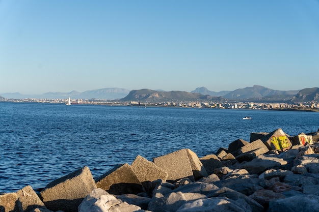 A rocky shoreline with a large body of water in the background