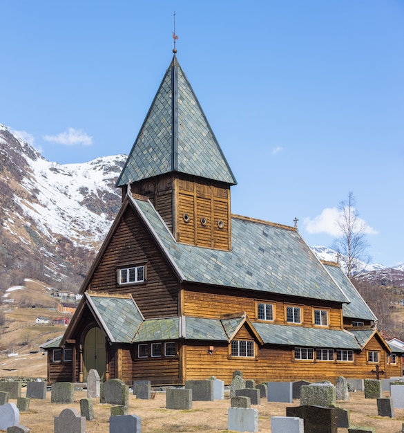 Roldal Stave Church (Roldal stavkyrkje) with snow cap mountain background