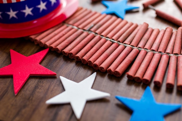 Roll of firecrackers with red, white and blue stars on wood table.