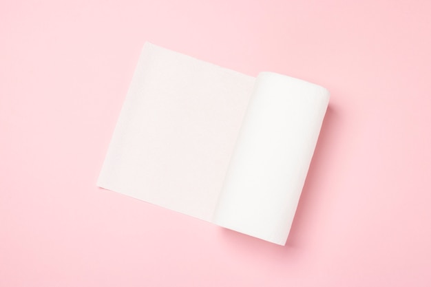 Roll of paper towels on a pink surface. Concept is 100 natural product, delicate and soft. Flat lay, top view. 