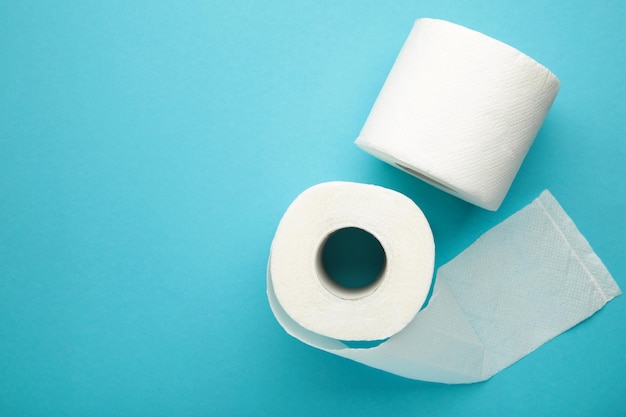 Roll of toilet paper on blue background Space for text