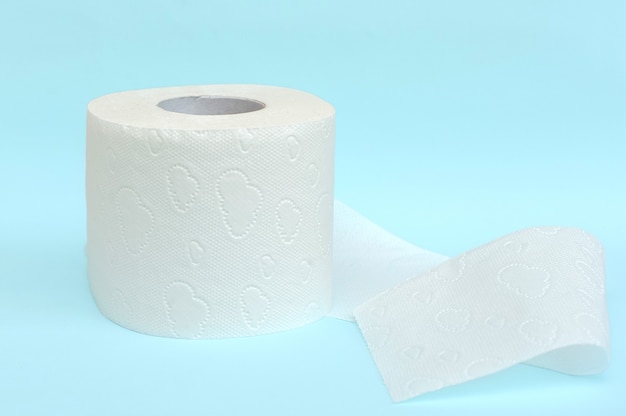 Roll of white toilet paper on blue background