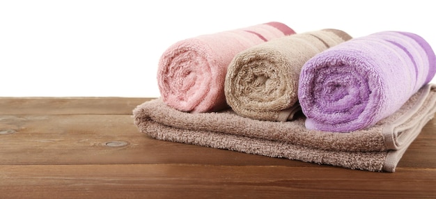 Rolled bath towels on wooden table closeup