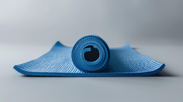 Rolled Blue Yoga Mat on a Gray Surface