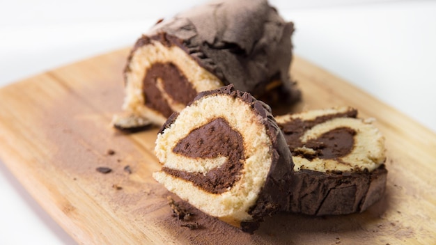 Rolled chocolate cake decorated as a Christmas log with chocolate.