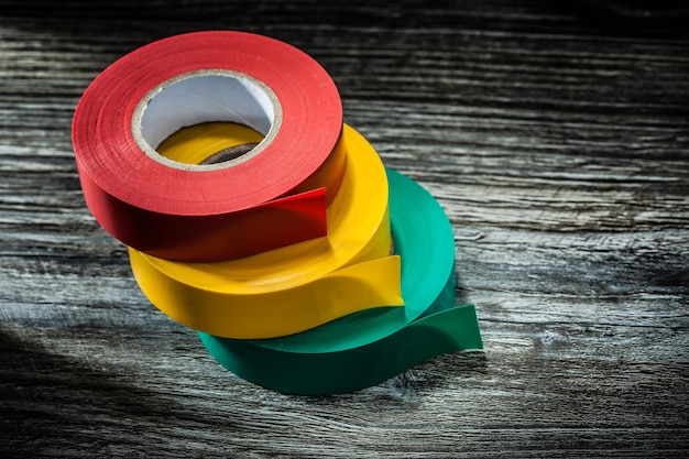 Rolled electricians tapes on wooden board