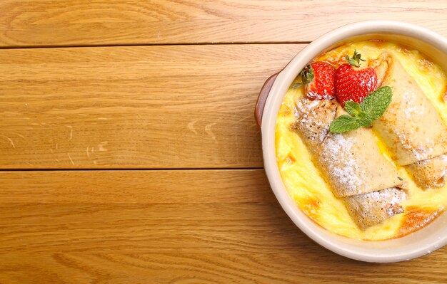 Rolled pancakes on a plate with honey and powdered sugar