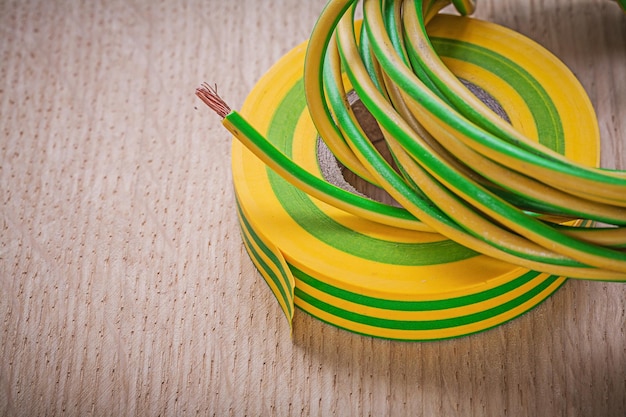 Rolled up insulating tape electrical cable on wooden board electricity concept