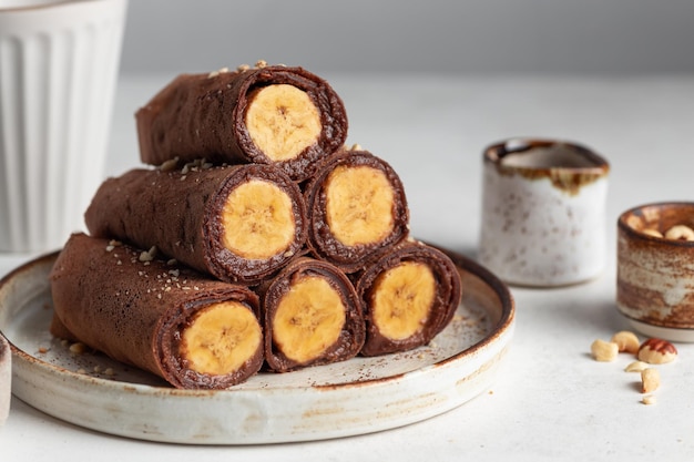 Rolled vegan chocolate crepes with banana filling