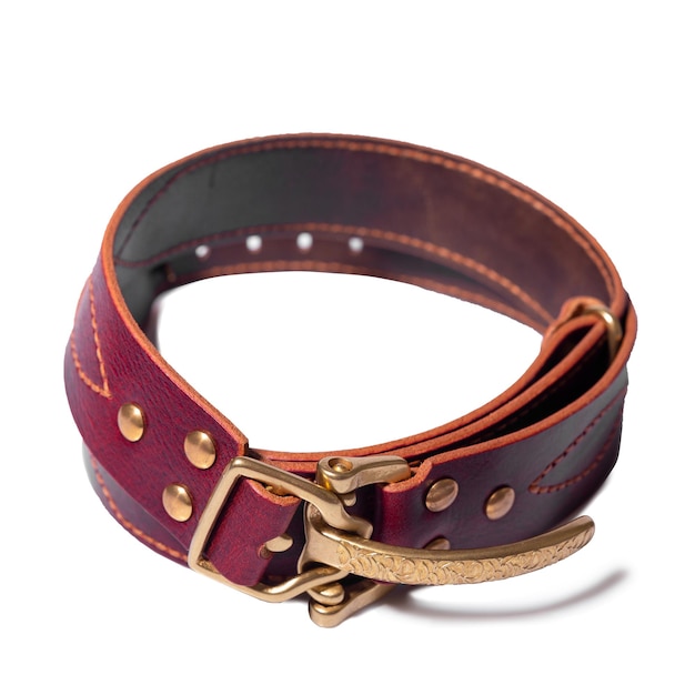 A rolledup brown leather belt with a metal buckle on a white background is isolated