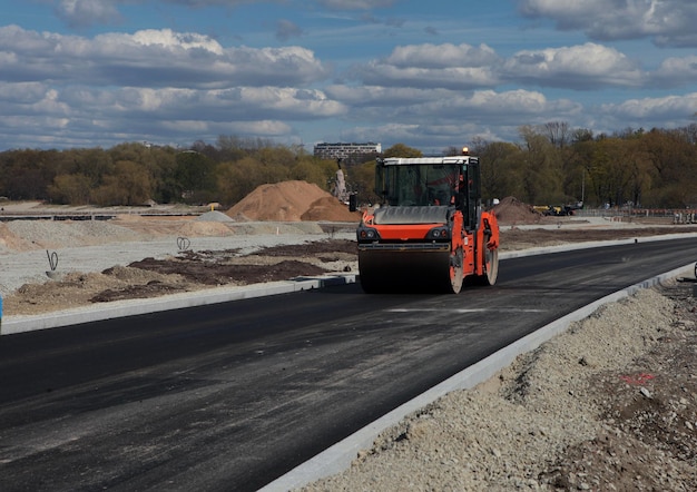 Roller rolling fresh hot asphalt on the new road Road construction