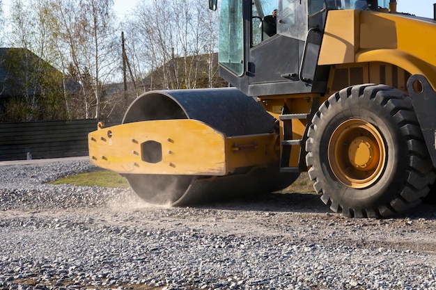 Photo the roller rolls the gravel preparing the soil for the road rural road repairs in kazakhstan