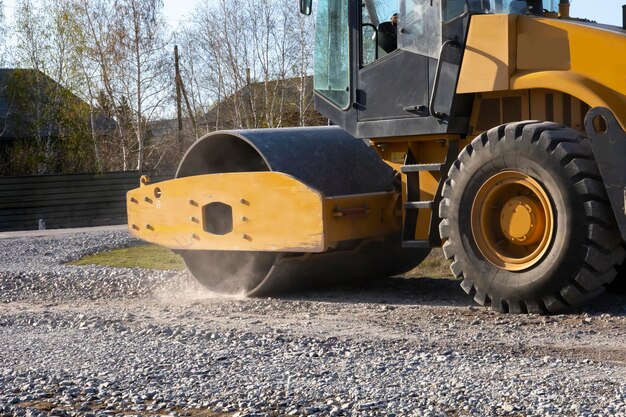 Photo the roller rolls the gravel preparing the soil for the road rural road repairs in kazakhstan