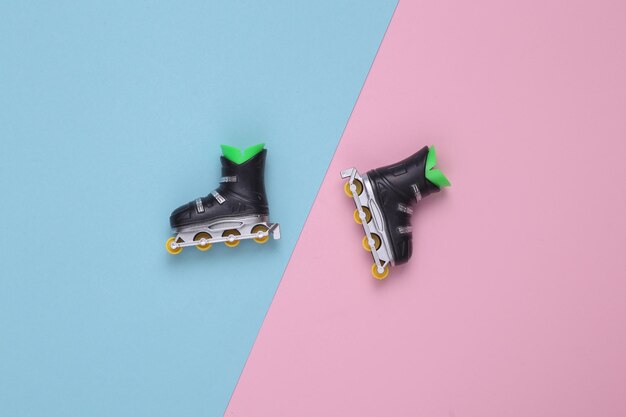 Roller skates on a bluepink pastel background Top view Flat lay