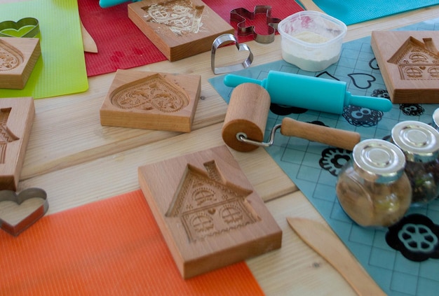 Rolling pin and floury gingerbread. Bakers hand spraying egg-white on gingerbreads