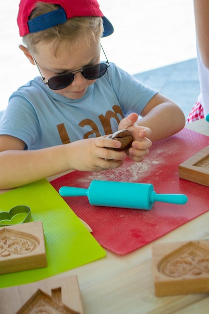 Rolling pin and floury gingerbread. Bakers hand spraying egg-white on gingerbreads