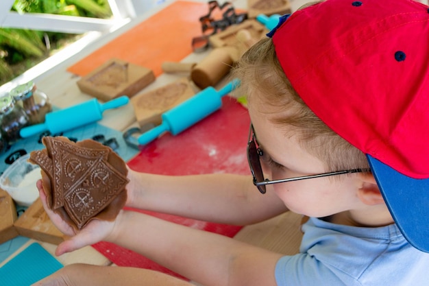 Rolling pin and floury gingerbread. Bakers hand spraying egg-white on gingerbreads